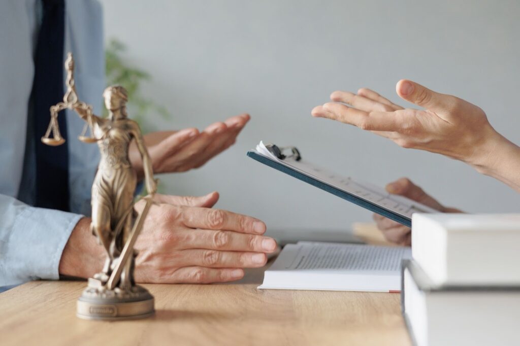 Two lawyers meeting in an office to discuss a Cancellation of Removal case.