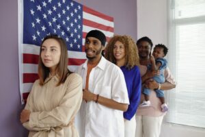 People lined up inside an immigration court with a US flag displayed on the wall behind them