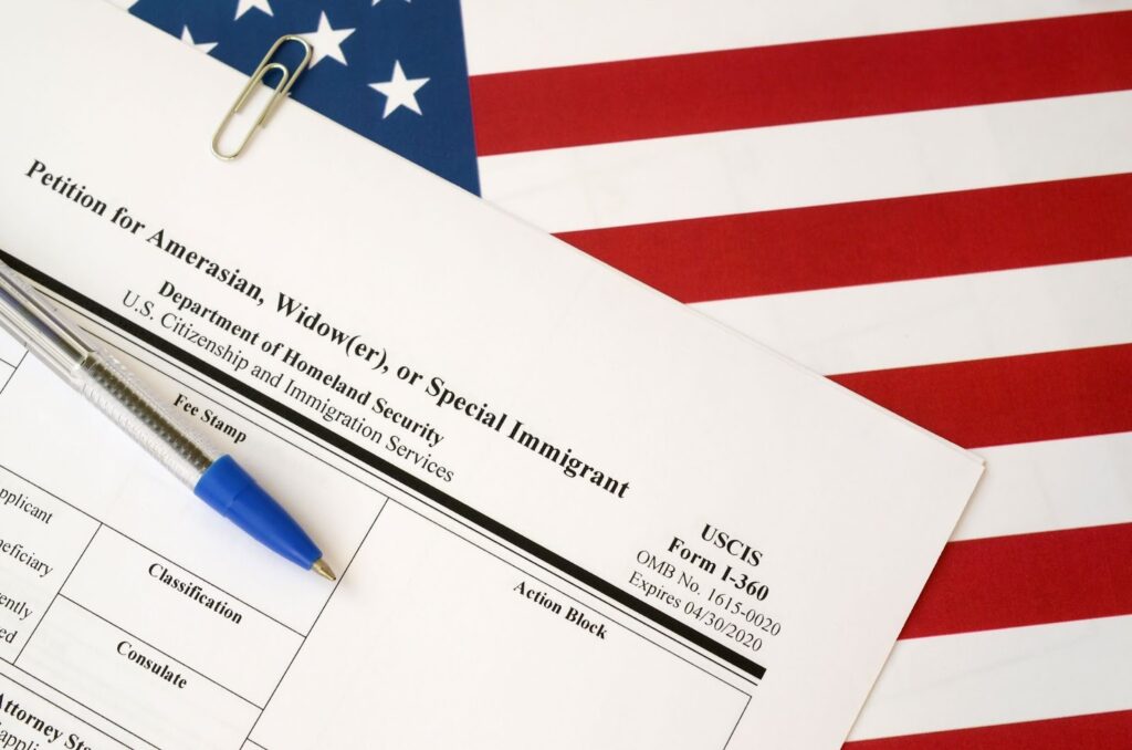 An I-360 petition for Special Immigrant status on top of the American flag.