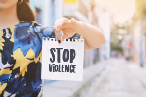 Woman holding a sign that says “stop violence.” 