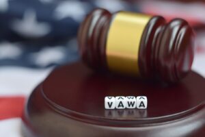 Close-up of a justice gavel next to letter blocks forming the VAWA acronym
