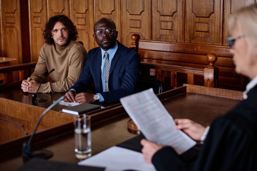 An attorney and client appear before a female judge during an immigration court case involving cancellation of removal