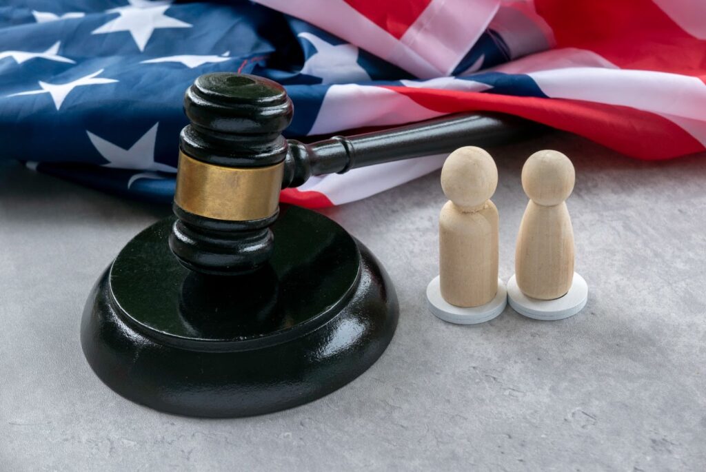 Gavel next to models of people and an American flag.