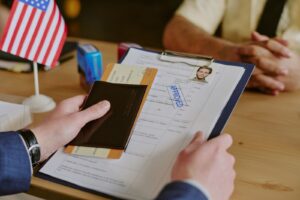 A man holding an approved visa application, along with a plane ticket and passport.