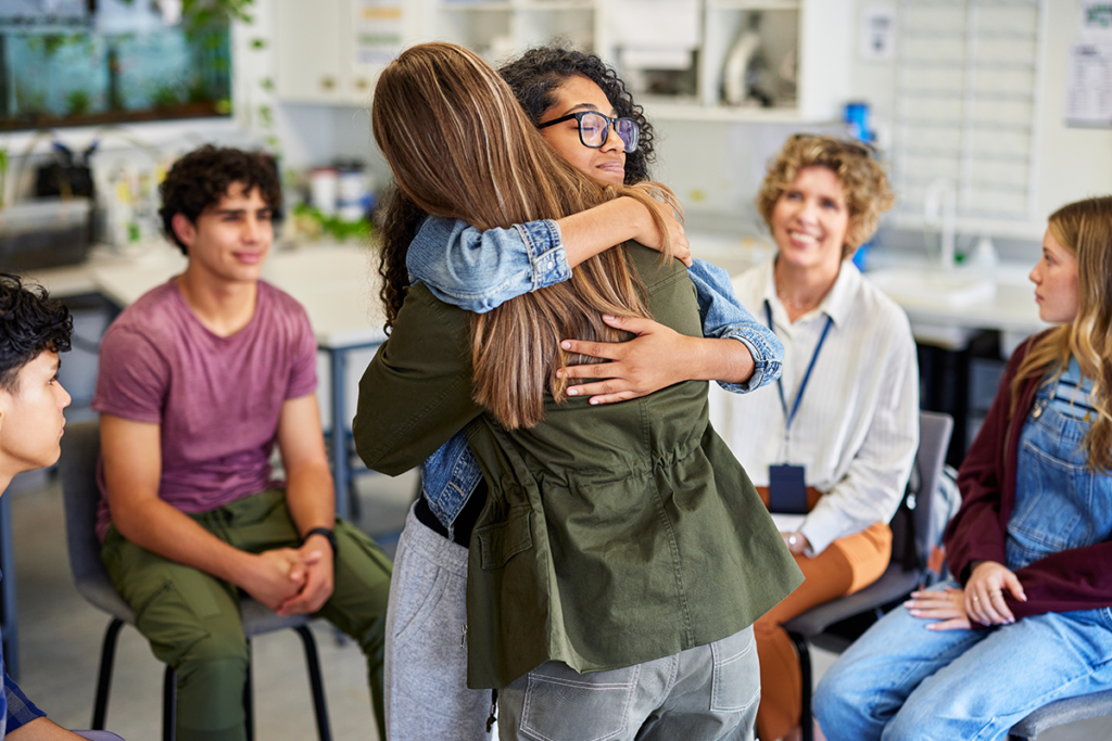 Special Immigration Juvenile. Special Immigration Juvenile. Friends hugging in a group setting.